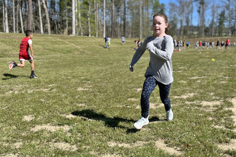 Young student running in grass