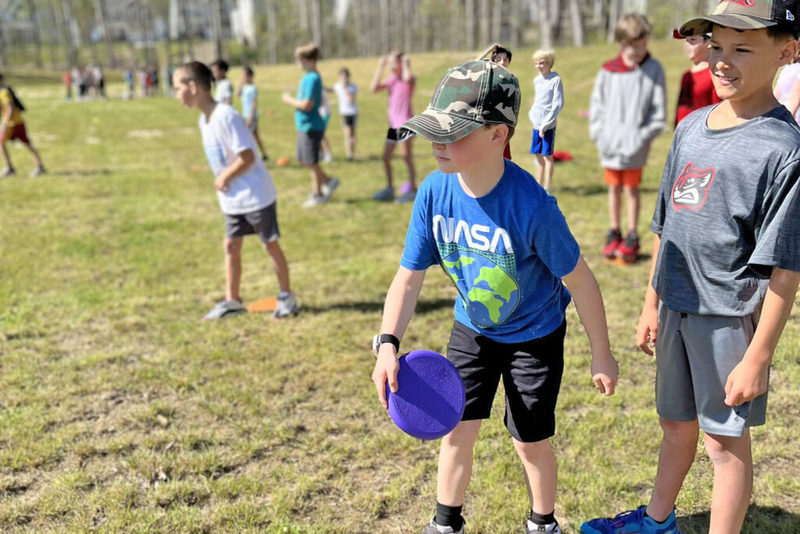 Young student throwing frisbee