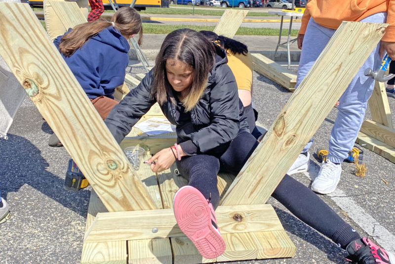 Student assembling picnic table