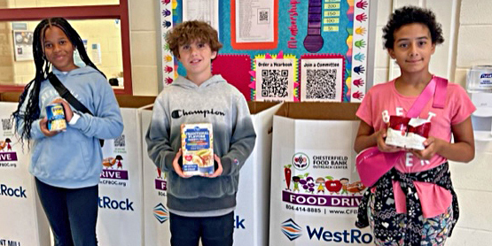 Three students smiling with food items