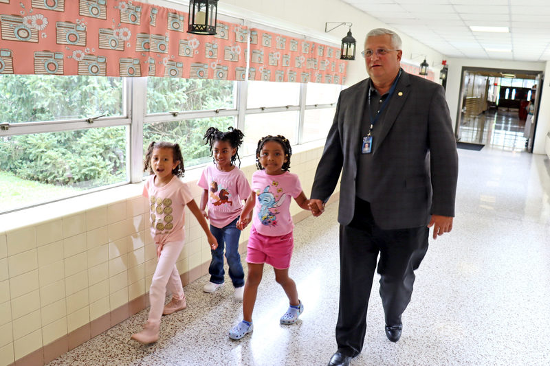 Superintendent walking with three young students