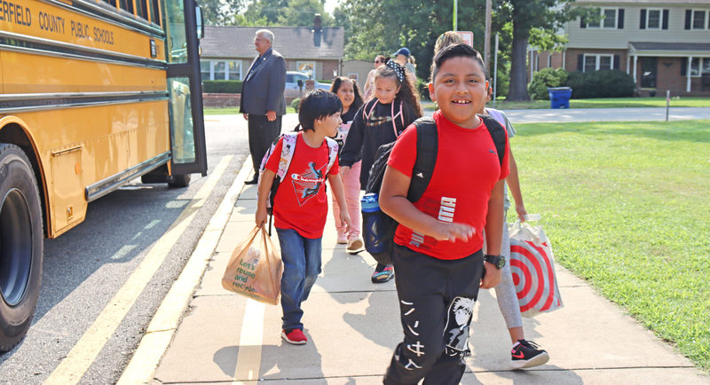 Smiling kids walking from school bus