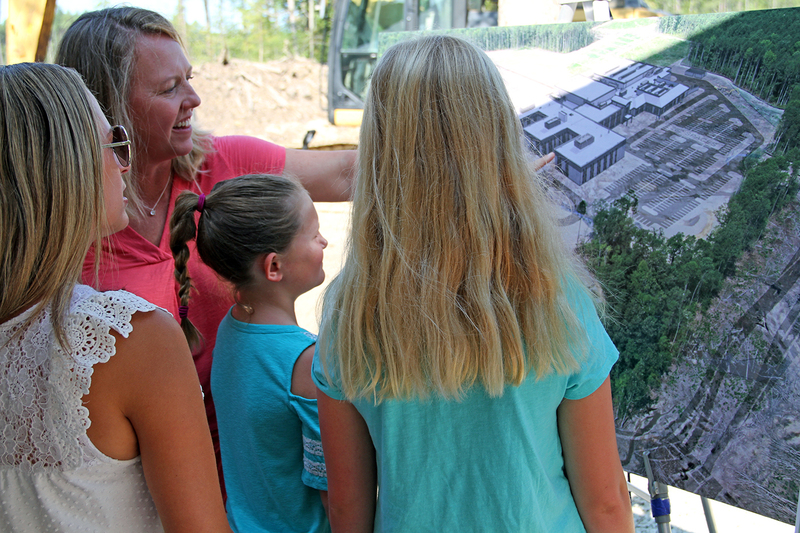 Adult showing building models to kids