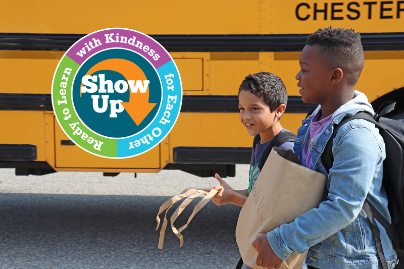 Students walking beside yellow school bus