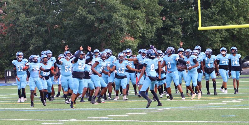 Football team cheering on field