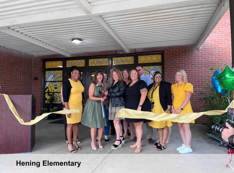 Adults cutting yellow ribbon